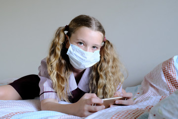 Schoolgirl wearing surgical mask in school uniform during Covid-19 / coronavirus pandemic