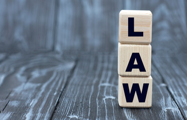 concept of the word LAW on cubes on a wooden gray background