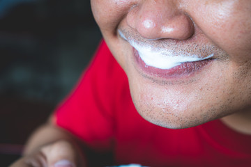 Close-up of a man's lips with milk foam attached