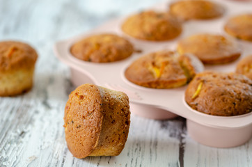 Delicious muffin with orange on a wooden table.
