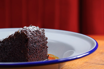 A slice of delicious chocolate cake. Piece of cake on a white plate with caramel. Sweet food.