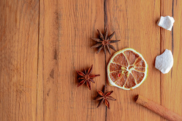 Dried orange, lemon, cinnamon sticks, anise star on rustic wooden background. Traditional mulled wine with spices.