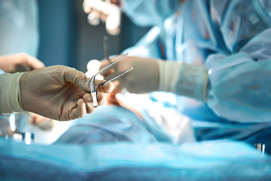 The surgeon's hands are holding an operating tool in the operating room. Close-up, beautiful light, modern medicine, Saving lives.