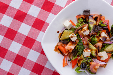 Dietary salad with vegetables, cheese feta, arugula and sauce. Traditional Italian cuisine, Italian concept.