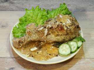 Baked turkey shin, leg in a plate with spices, garlic, pepper, jelly, lettuce leaves, fresh...