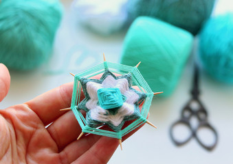 Wicker mandala made of blue yarn on wooden toothpicks. Flower pattern.