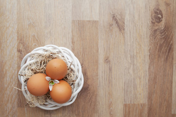 Easter eggs  in nest on wooden rustic table, holiday background for your decoration. Spring and Easter holiday concept with copy space.