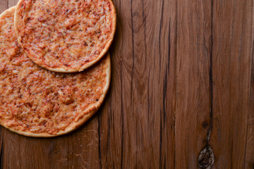 Two pizzas on the dark rustic wooden table. Flat lay, top view. Copy space web design banner.