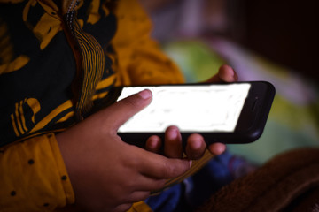 little boy using a black mobile phone 