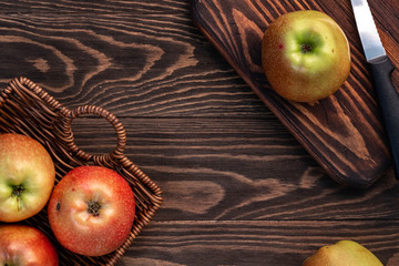 Fresh and juicy red apples in a basket on a wooden table