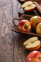 Fresh and juicy red apples in a basket on a wooden table
