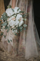 Wedding bride bouquet. Bridesmaids holding pastel flower bouquet in their hands. Bridesmaids and bride dressed in soft berry dress