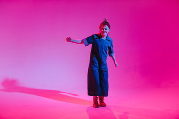 Young stylish girl dancing in the Studio on a colored neon background. Music dj poster design.
