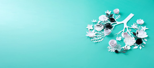 Foci in the lungs in the form of flowers made of black paper against the background of light white flowers