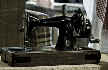 Antique sewing machine on a small wooden pedestal