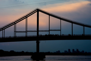 Silhouette of a high bridge over the river against the sky