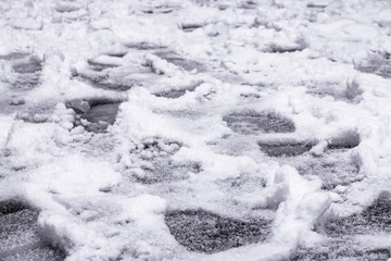 Not clear footprints in the white snow cover. 