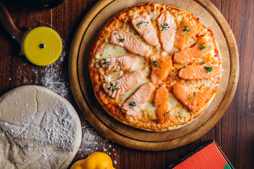 salmon Italian Pizza on wooden table