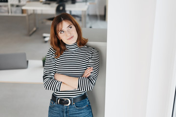 Thoughtful young woman standing looking up