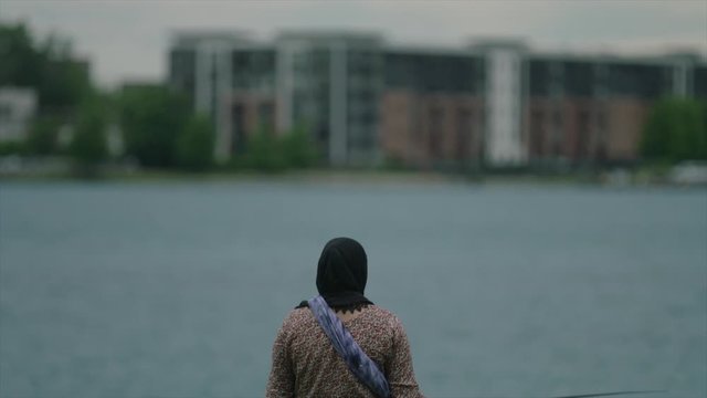 Woman fishing in Hijab on Detroit River