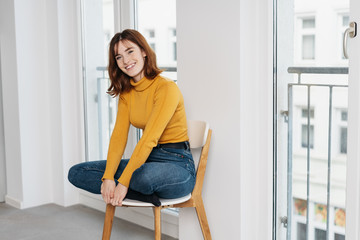 Pretty young student relaxing on a chair