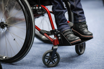 Details of an ill disabled young boy in a wheelchair.