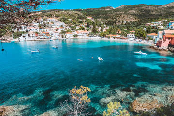 View on tourquise transparent bay of mediterranean village Assos framed through green pine grove. Shadow pattern. Kefalonia Greece