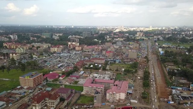 Aerial footage flying over low-rise residential neighborhoods contrasting with commercial office towers and skyline Nairobi Kenya, changing urban landscapes Kenya Africa