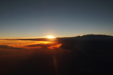 Fototapeta na wymiar mysterious sunset with clouds from the airplane window with
