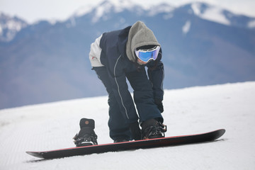 Fototapeta na wymiar スノーボードを装着する女性スノーボーダー