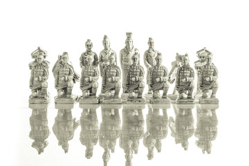 A view of several white chess pieces. Ceramic chess pieces against white color background