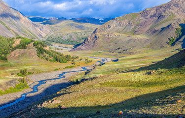 Fototapeta premium Mountain valley. Tundra, treeless mountain slopes, wild river. Traveling in the mountains, trekking.