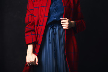 Fototapeta na wymiar Hands of a young stylish girl in fashionable clothes of red and blue color.
