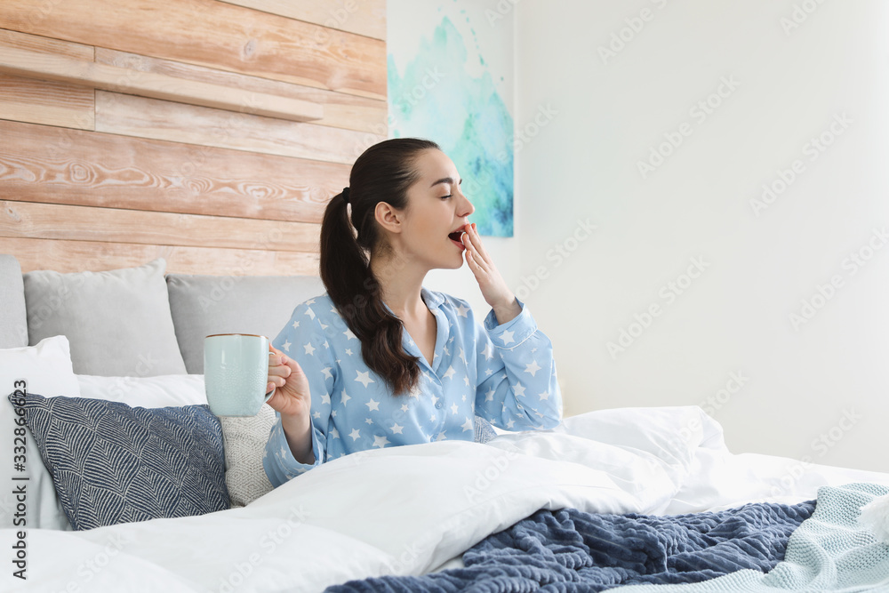 Wall mural Woman awakening in large bed at home. Elegant interior