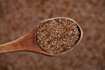 Macro shot with focus on flax on a wooden spoon. Eco-friendly product for digestion and stomach