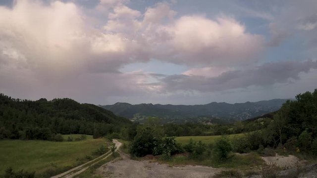 Timelapse of a sunrise over green hills with cloudy sky