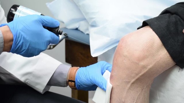 Medical Doctor Preparing and Injecting Platelet Rich Plasma PRP into Patient's Knee