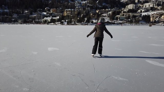 Young Girl Iceskating on Frozen Lake in Swiss St. Moritz in sunny weather 4K