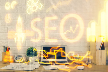 Double exposure of table with computer and seo drawing hologram. Search optimization concept.