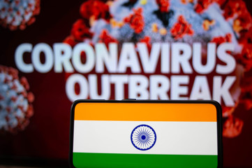 Indian Flag on a mobile in front of a banner of Coronacirus outbreak