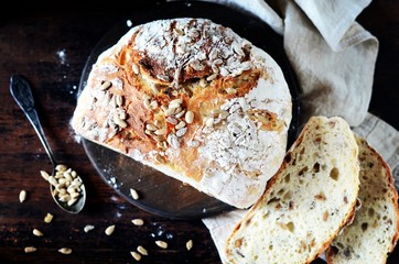 Homemade bread with sunflower seeds on a dark wooden background