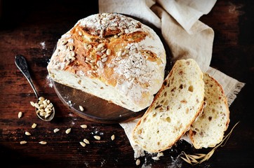 Homemade bread with sunflower seeds on a dark wooden background