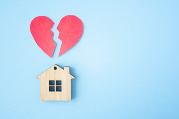 Divorce, division of property, poverty and no money concept. Wooden house with broken heart on...