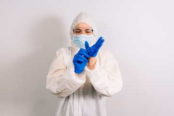 Fototapeta na wymiar Infection Control Medical Specialist in a protective suit and respirator wearing gloves for scientific and coronavirus COVID 19 experiments and other diseases. Isolated