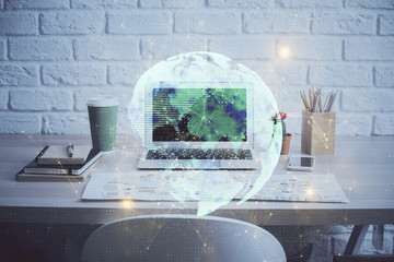 Computer on desktop with social network hologram. Multi exposure. Concept of international people connections.