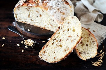 Homemade bread with sunflower seeds on a dark wooden background