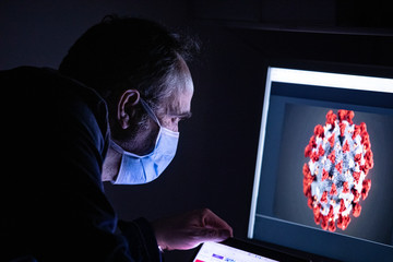 ricercatore verifica dati sul coronavirus (covid-19) davanti al suo monitor