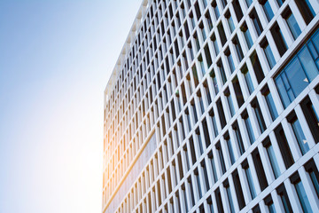 View of office building  with sunrise, reflection and perspective. Bright outlook for business. Modern office block with sunny beautiful sky.