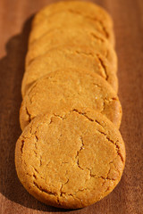 A row of ginger biscuits on a dark wooden background