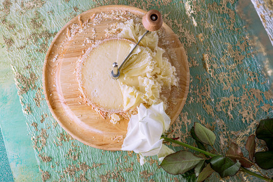 Scraper For Slicing And Tasting Tasty Cheese Chips On Gold Tablecloth. White Rose Flower.